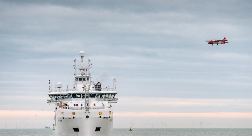 The Belgian Coast Guard Aircraft in action over the oceanographic research vessel 'Belgica'.